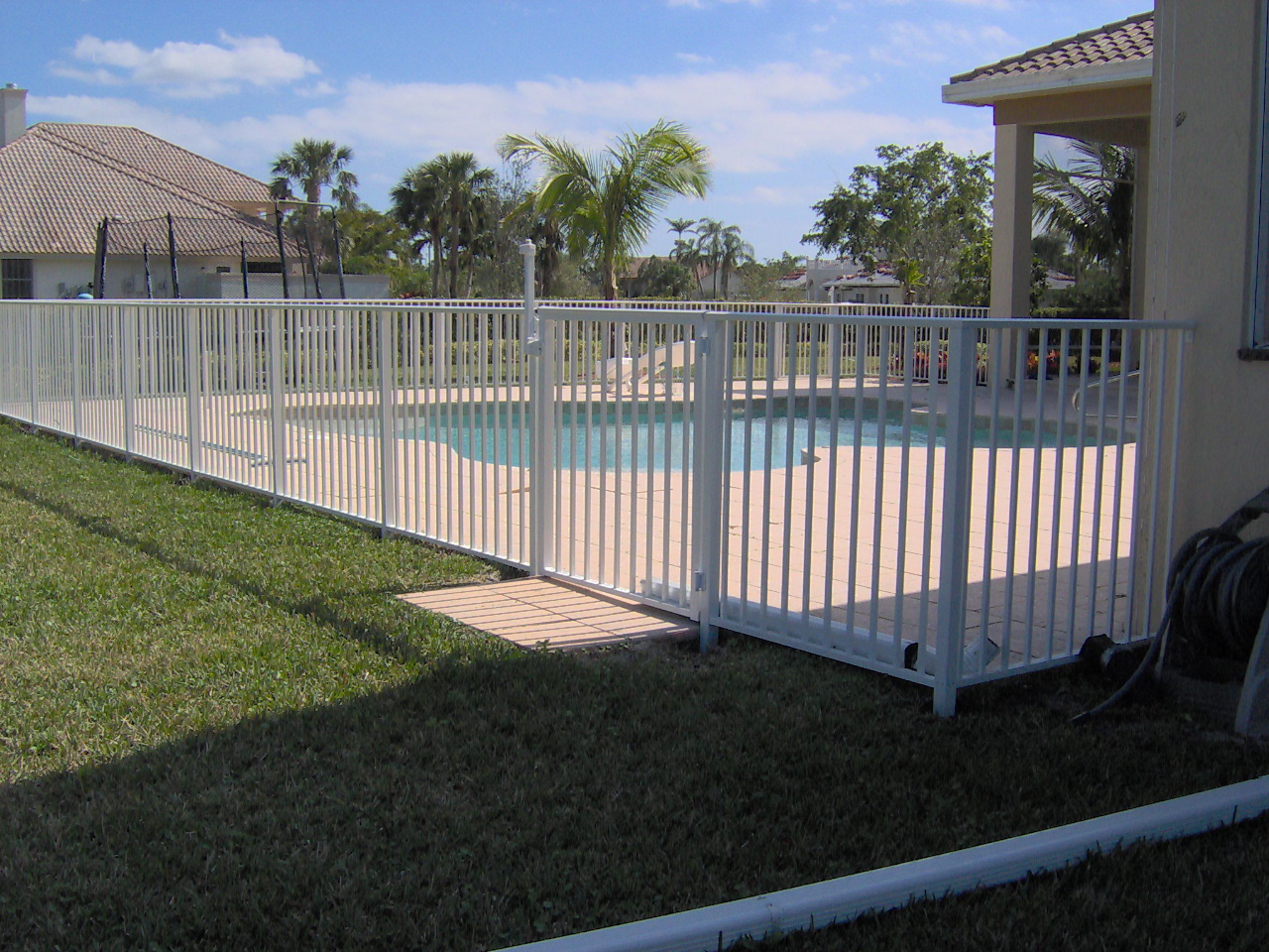 White aluminum pool safety fence with self-closing gate